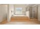Spacious bathroom with a tub, glass block window, and glass-enclosed shower at 8056 Revere Dr, Mcdonough, GA 30252
