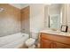 Bathroom with bathtub, tiled walls, single vanity and fixtures at 8056 Revere Dr, Mcdonough, GA 30252