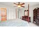 Spacious bedroom featuring a ceiling fan, wooden furniture, and an ensuite bathroom with a tub and shower at 8056 Revere Dr, Mcdonough, GA 30252
