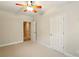 Neutral bedroom featuring wall-to-wall carpet, a ceiling fan, and multiple doors, leading to other rooms at 8056 Revere Dr, Mcdonough, GA 30252