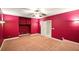Spacious carpeted bonus room with an elevated platform and red walls, offering versatility and style at 8056 Revere Dr, Mcdonough, GA 30252
