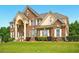 Stately two-story brick home with well-manicured lawn and symmetrical landscaping at 8056 Revere Dr, Mcdonough, GA 30252