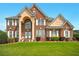 Stately two-story brick home with well-manicured lawn and symmetrical landscaping at 8056 Revere Dr, Mcdonough, GA 30252