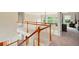 Upstairs hallway featuring hardwood railing, carpet, lots of natural light, and access to bedrooms at 8056 Revere Dr, Mcdonough, GA 30252