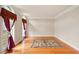 Bright living room featuring hardwood floors, area rug, and elegant curtains at 8056 Revere Dr, Mcdonough, GA 30252