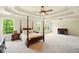 Spacious primary bedroom with tray ceilings, fireplace and sitting area with plenty of natural light at 8056 Revere Dr, Mcdonough, GA 30252