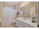 Bathroom with a tub-shower combo, white cabinets, and soft lighting at 8424 Fairway Dr, Covington, GA 30014