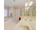 Bright bathroom with tiled floors, a large mirror, and a tub with gold fixtures at 8424 Fairway Dr, Covington, GA 30014