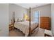 Bedroom with four-poster bed, side table, and a wooden dresser near the window at 8424 Fairway Dr, Covington, GA 30014