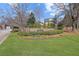 Community entrance featuring a stone wall, manicured landscaping, and a welcoming sign at 8424 Fairway Dr, Covington, GA 30014