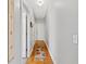 Hallway with hardwood floors, a patterned runner, and doorways leading to rooms at 8424 Fairway Dr, Covington, GA 30014