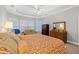 Spacious main bedroom showcasing soft carpet, an orange patterned comforter, and a trey ceiling at 8424 Fairway Dr, Covington, GA 30014