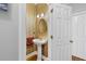 Elegant powder room with a pedestal sink, oval mirror, decorative lighting, and striped wallpaper at 8424 Fairway Dr, Covington, GA 30014