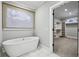 Bathroom featuring a freestanding tub next to a window and a door to the walk-in closet at 2262 Abby Ne Ln, Atlanta, GA 30345