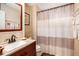 Bathroom featuring granite vanity with decorative mirror and a tiled shower with decorative curtain at 97 Old Burnt Hickory Rd, Acworth, GA 30101