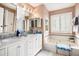 Elegant bathroom featuring double sinks, a soaking tub, and shuttered windows for privacy at 97 Old Burnt Hickory Rd, Acworth, GA 30101