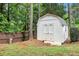 A white wooden shed in the backyard, offering ample storage space with double doors and a small window at 97 Old Burnt Hickory Rd, Acworth, GA 30101