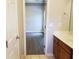 An inviting bathroom shows a granite counter with wood cabinets, and an open doorway to a bedroom with wood-look floors at 1059 Sims Sw St, Atlanta, GA 30310