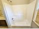 The white tub shower has a handheld showerhead and a storage shelf for toiletries at 1059 Sims Sw St, Atlanta, GA 30310