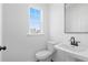 Bathroom features a white toilet, sink, light and white walls at 3186 Eastham Run Dr, Dacula, GA 30019