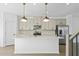 Modern kitchen featuring a center island with stainless steel appliances, pendant lighting, and white cabinets at 3186 Eastham Run Dr, Dacula, GA 30019