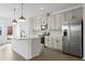 Modern kitchen with stainless steel appliances, pendant lighting, white cabinets, and an island at 3186 Eastham Run Dr, Dacula, GA 30019