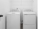 Laundry room with modern washer and dryer appliances set up and wire rack shelving above at 3186 Eastham Run Dr, Dacula, GA 30019