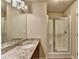 Bathroom featuring single sink vanity with granite countertop, dark cabinets, and glass shower at 3082 Cedar Glade Ne Ln, Buford, GA 30519