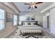 Spacious bedroom featuring tray ceiling, ceiling fan, large bed, bench and neutral decor at 3082 Cedar Glade Ne Ln, Buford, GA 30519
