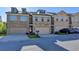 Townhouse exterior featuring brick and stone accents, a two-car garage, and well-manicured front lawn at 3082 Cedar Glade Ne Ln, Buford, GA 30519
