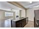 Open kitchen with dark cabinets, granite counters, island, and stainless steel appliances at 3082 Cedar Glade Ne Ln, Buford, GA 30519
