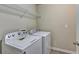 Functional laundry room featuring white washer and dryer, and wire shelving unit for storage at 3082 Cedar Glade Ne Ln, Buford, GA 30519