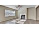 Spacious living room featuring a fireplace, hardwood floors, large window and ceiling fan at 3082 Cedar Glade Ne Ln, Buford, GA 30519