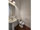 Powder room with pedestal sink, toilet, and dark wood-look flooring at 3794 Allegretto Cir, Atlanta, GA 30339