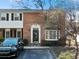 Two-story brick townhouse with a decorative front door, bay window, and a black SUV parked in front at 6520 Roswell Rd # 74, Atlanta, GA 30328