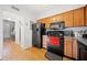 Kitchen with wood cabinets, hardwood floors, and black appliances at 6520 Roswell Rd # 74, Atlanta, GA 30328