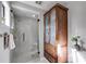 Bathroom featuring a glass shower, cabinet with glass doors and a small plant next to the toilet at 3261 Turtle Lake Se Ct, Marietta, GA 30067