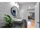 Bright bathroom with a round mirror, modern sink, textured accent wall, and door into bedroom at 3261 Turtle Lake Se Ct, Marietta, GA 30067