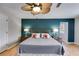 Well-lit bedroom with dark teal accent wall, hardwood floors, and matching bedside tables at 3261 Turtle Lake Se Ct, Marietta, GA 30067