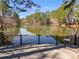 Scenic view of a private lake from a wooden deck, complete with seating, perfect for relaxation at 3261 Turtle Lake Se Ct, Marietta, GA 30067
