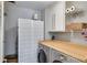 Efficient laundry room featuring a wooden countertop, storage cabinets and baskets, and a folding screen at 3261 Turtle Lake Se Ct, Marietta, GA 30067