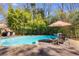Enjoy outdoor dining by the pool with a charming patio setup and stylish umbrella at 3261 Turtle Lake Se Ct, Marietta, GA 30067