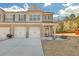 Charming townhome features a brick facade, attached garages, and a well-manicured lawn at 7207 Brigidoon Rose, Douglasville, GA 30134