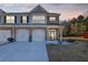 Charming townhome features a brick facade, attached garages, and a well-manicured lawn at dusk at 7207 Brigidoon Rose, Douglasville, GA 30134