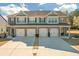 Exterior view of brick townhomes with attached garages and manicured lawns at 7207 Brigidoon Rose, Douglasville, GA 30134