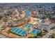 Aerial view of the community, with tennis courts, a lake, and tree-lined streets at 1175 Lamont Cir, Dacula, GA 30019