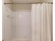 Clean white tiled shower with white shower curtain at 1175 Lamont Cir, Dacula, GA 30019