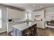 This kitchen island features white cabinets, seating for three, hardwood floors, and stainless steel appliances at 1175 Lamont Cir, Dacula, GA 30019