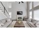 The living room has a staircase, tall windows, a fireplace, a ceiling fan, hardwood floors, and a seating area at 1175 Lamont Cir, Dacula, GA 30019