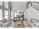 The living room has a staircase, tall windows, hardwood floors, a seating area, and a view of the kitchen at 1175 Lamont Cir, Dacula, GA 30019